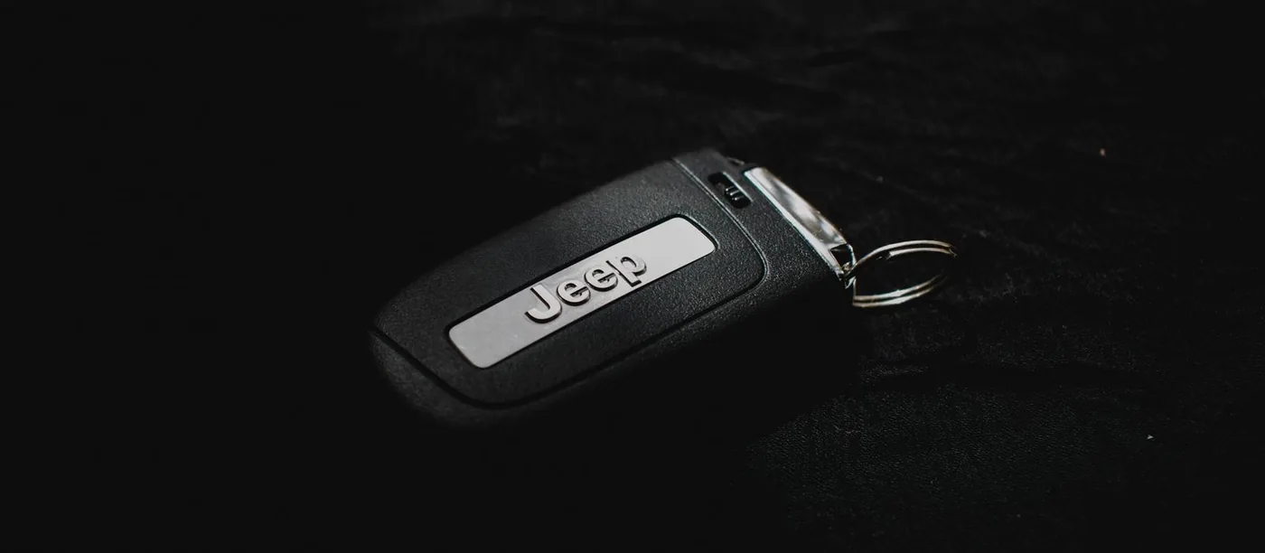 Black car key fob with a key ring on a dark surface